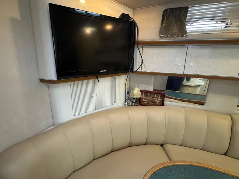Slide: The Image of Interior of 1995 Sea Ray 450 Sundancer with TV and beige seating area. - 15