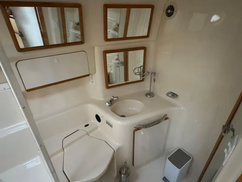 Slide: The Image of Bathroom interior of 1995 Sea Ray 450 Sundancer yacht, featuring mirrors and sink. - 16