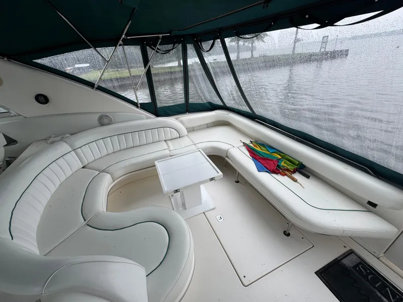 Slide: The Image of 1995 Sea Ray 450 Sundancer interior with white seating and rain-covered windows. - 23
