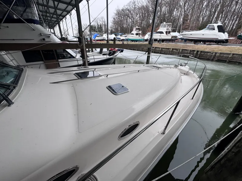 Slide: The Image of 1995 Sea Ray 450 Sundancer docked under a covered marina with other boats nearby. - 3