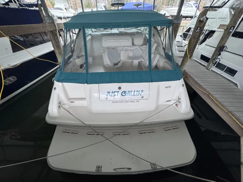 Slide: The Image of 1995 Sea Ray 450 Sundancer docked, featuring a teal canopy and spacious deck. - 5