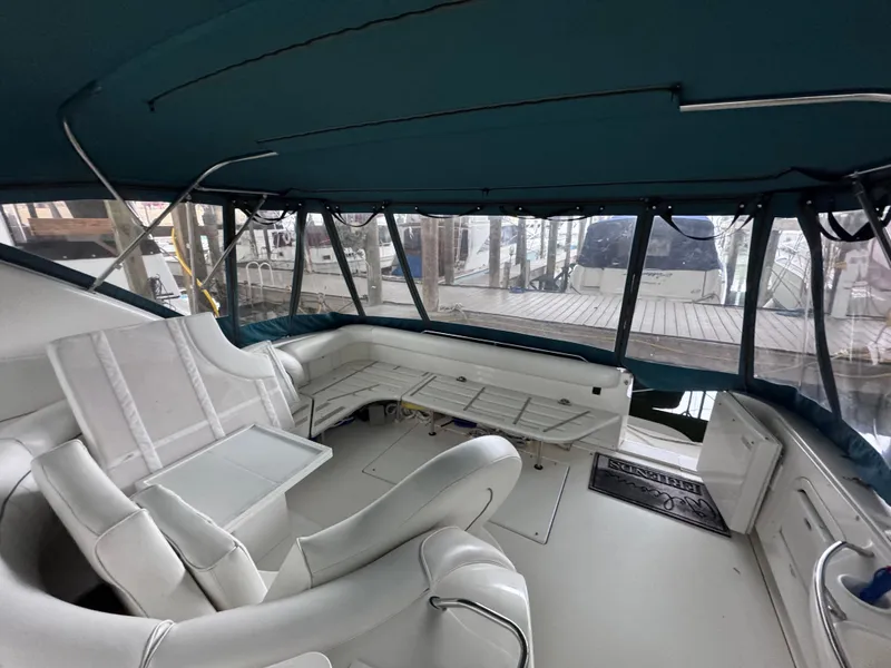 Slide: The Image of Interior of a 1995 Sea Ray 450 Sundancer yacht with white seating and teal canopy. - 7