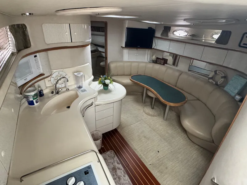 Slide: The Image of Luxurious interior of 1995 Sea Ray 450 Sundancer yacht with kitchen and seating area. - 9