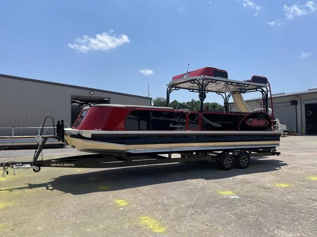 Slide: The Image of 2025 Aloha 30' Paradise Sundeck boat on trailer in industrial area. - 10