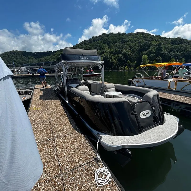 Slide: The Image of 2025 Aloha 30' Paradise Sundeck boat docked on a sunny day, surrounded by lush greenery. - 2