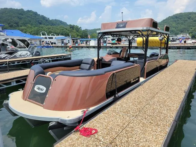 Slide: The Image of 2025 Aloha 30' Paradise Sundeck boat docked at a scenic marina. - 21