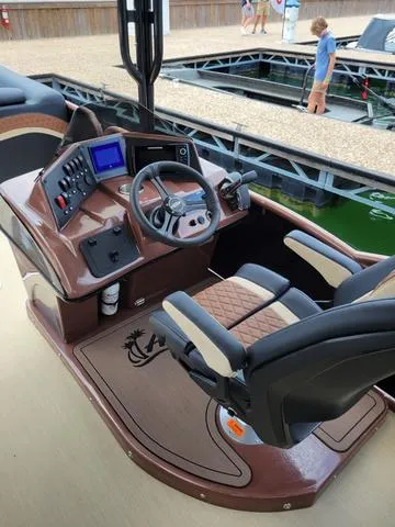 Slide: The Image of 2025 Aloha 30' Paradise Sundeck boat helm with modern controls and comfortable seating. - 27