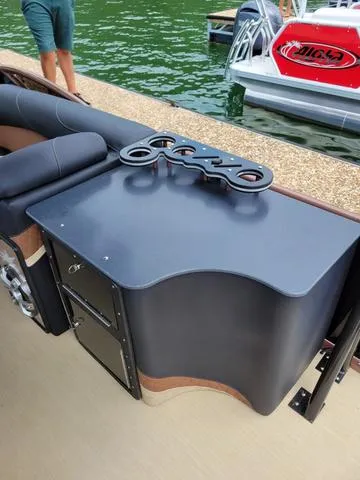 Slide: The Image of 2025 Aloha 30' Paradise Sundeck boat with sleek black counter and cup holders. - 30