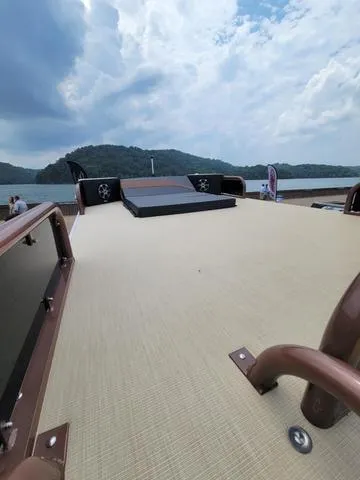Slide: The Image of 2025 Aloha 30' Paradise Sundeck on a serene lake with cloudy sky. - 31