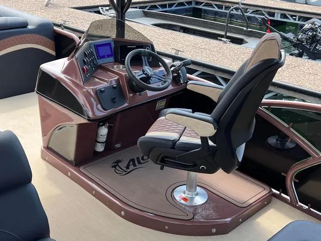 Slide: The Image of Helm of 2025 Aloha 30' Paradise Sundeck boat with modern controls and seating. - 38