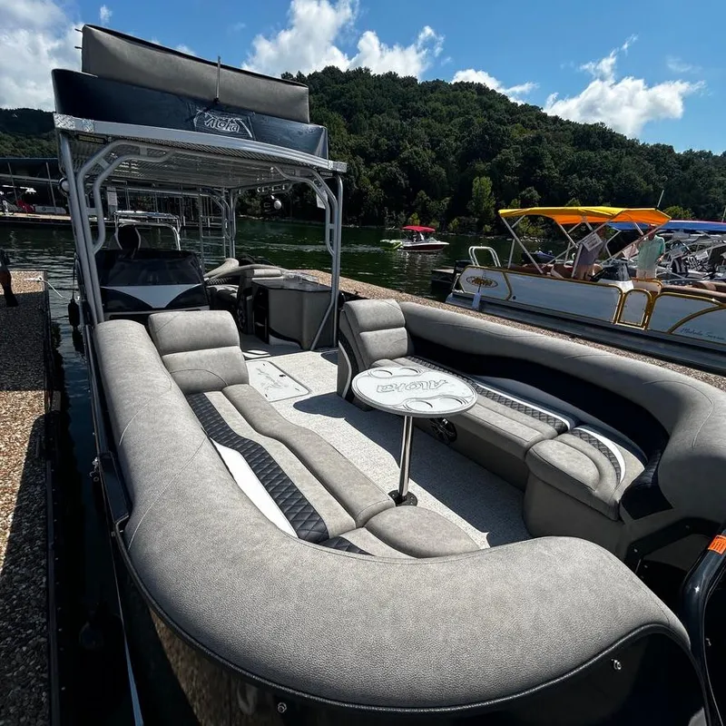 Slide: The Image of 2025 Aloha 30' Paradise Sundeck boat with spacious seating, docked by a scenic lake. - 4