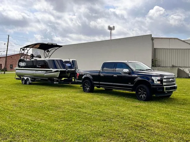 Slide: The Image of Aloha 2025 23' Paradise Arch Sport Tower boat towed by a black pickup truck. - 15