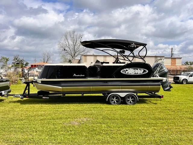Slide: The Image of 2025 Aloha 23' Paradise Arch Sport Tower boat on trailer, parked on grass. - 20