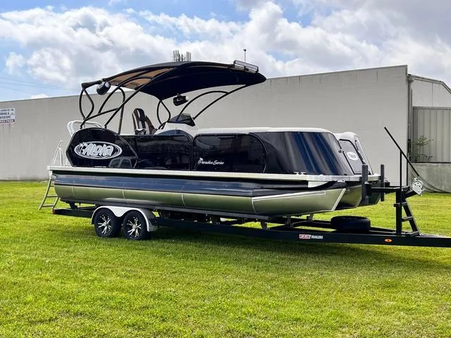 Slide: The Image of 2025 Aloha 23' Paradise Arch Sport Tower pontoon boat on trailer, parked on grass. - 21
