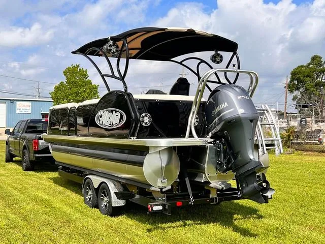 Slide: The Image of Aloha 2025 23' Paradise Arch Sport Tower boat on trailer, parked on grass. - 29
