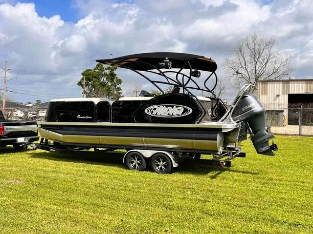 Slide: The Image of 2025 Aloha 23' Paradise Arch Sport Tower boat on trailer, parked on grass. - 3