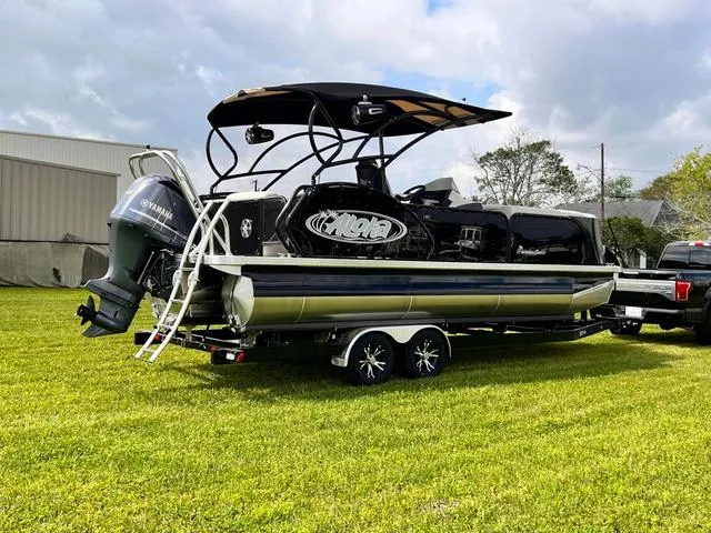 Slide: The Image of 2025 Aloha 23' Paradise Arch Sport Tower boat on trailer, parked on grass. - 6