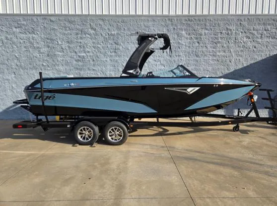 The Image of 2025 Tigé Z3 boat on trailer, black and blue design, parked outdoors. - 1