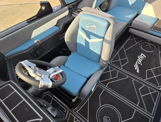 Slide: The Image of 2025 Tigé Z3 boat interior with blue and gray seating, modern steering wheel, and branded flooring. - 6