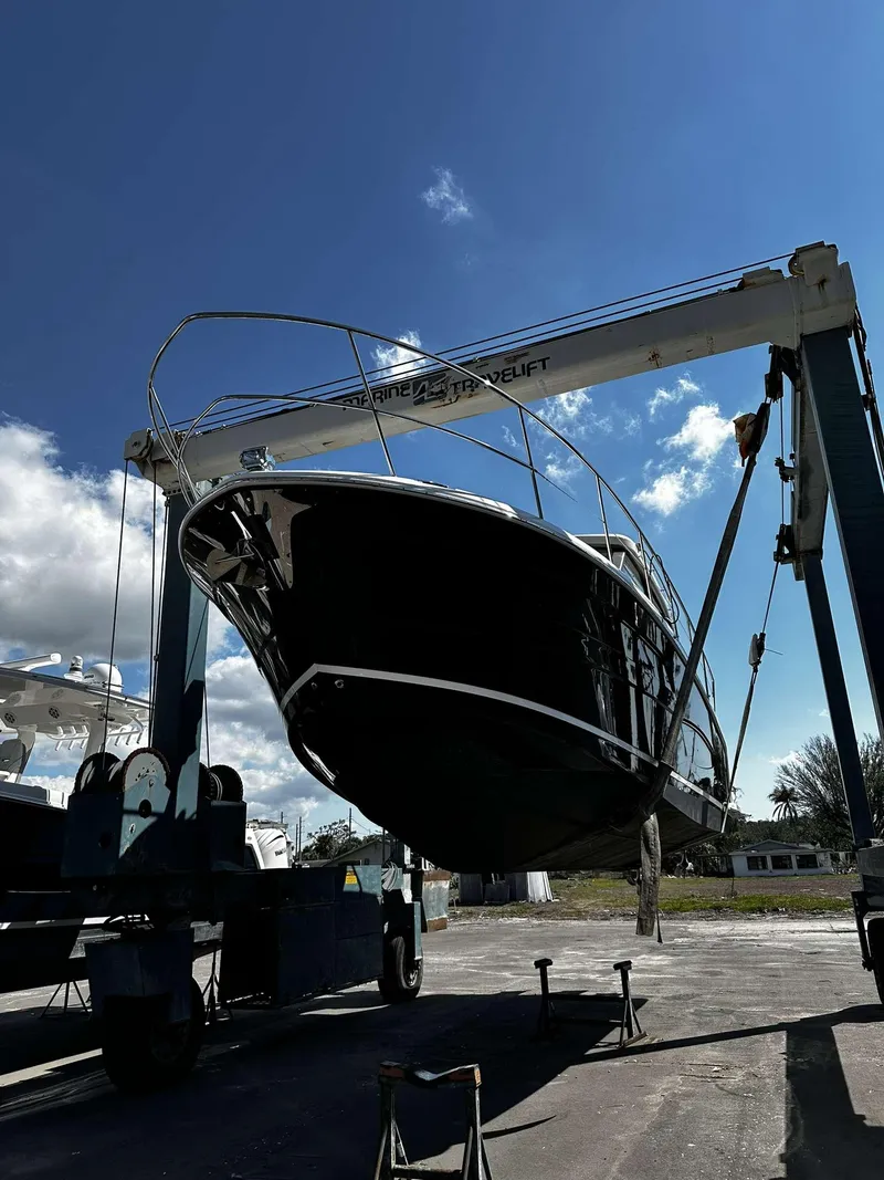 Slide: The Image of 2021 Regal 38 XO boat lifted by crane under clear blue sky. - 11