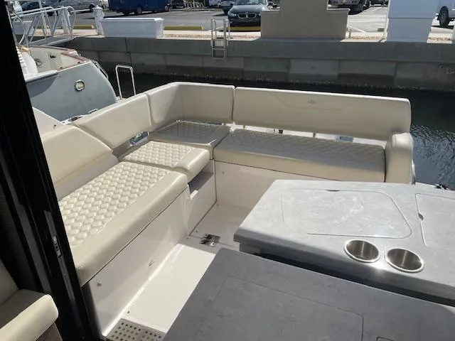 Slide: The Image of 2021 Regal 38 XO boat interior with beige seating and table, docked at marina. - 17