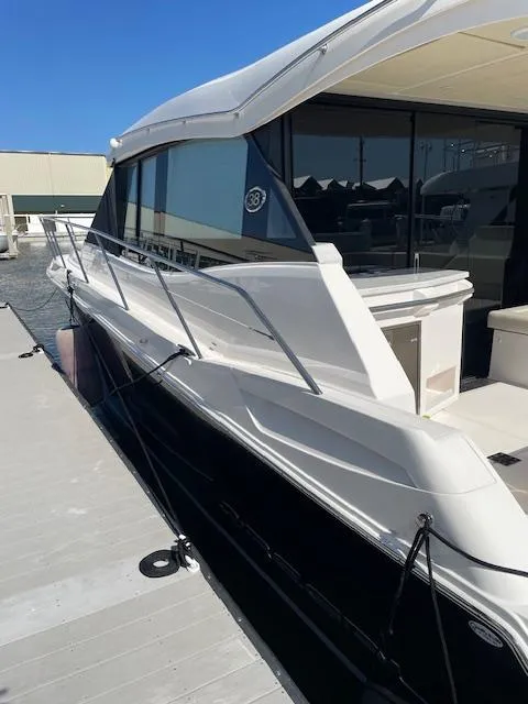 Slide: The Image of 2021 Regal 38 XO yacht docked at marina, showcasing sleek design and modern features. - 2