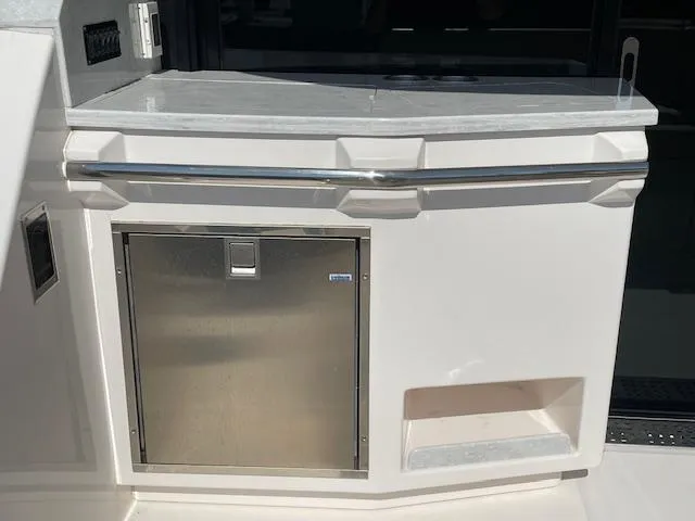 Slide: The Image of 2021 Regal 38 XO yacht kitchenette with stainless steel fridge and countertop. - 21