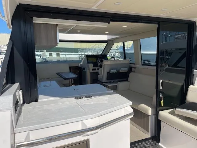 Slide: The Image of 2021 Regal 38 XO yacht interior with modern seating and navigation area. - 26