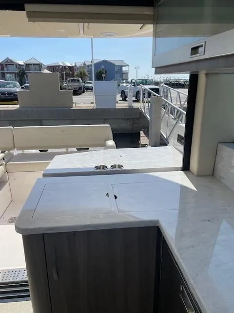 Slide: The Image of 2021 Regal 38 XO yacht interior with sleek countertops and marina view. - 30