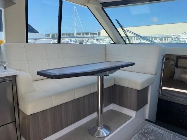 Slide: The Image of 2021 Regal 38 XO yacht interior with white seating and sleek table design. - 36