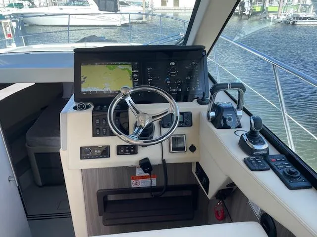 Slide: The Image of 2021 Regal 38 XO yacht helm with modern navigation controls and steering wheel. - 38