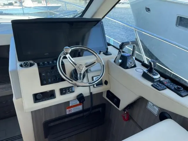 Slide: The Image of 2021 Regal 38 XO yacht helm with steering wheel and control panel. - 39
