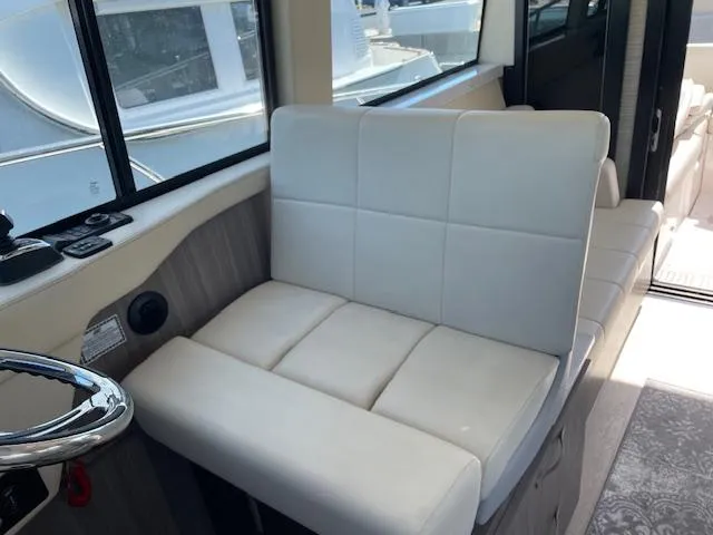 Slide: The Image of 2021 Regal 38 XO boat interior with white cushioned seating and steering wheel. - 41