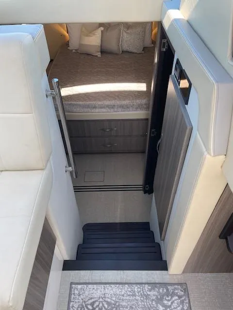 Slide: The Image of Interior cabin view of 2021 Regal 38 XO yacht, featuring stairs and a cozy bed. - 42