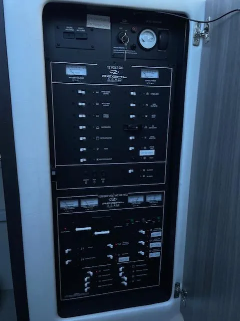 Slide: The Image of Electrical control panel of a 2021 Regal 38 XO boat, featuring various switches and gauges. - 43