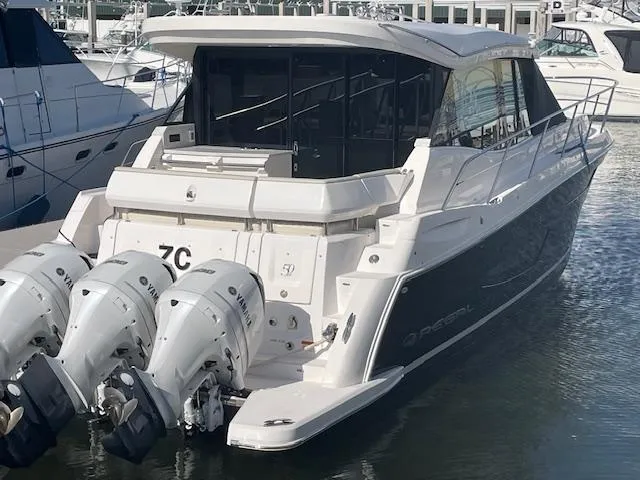 Slide: The Image of 2021 Regal 38 XO boat with triple outboard engines docked at marina. - 5