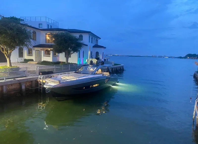 Slide: The Image of Azimut Verve 47 yacht docked by a waterfront house at dusk, 2021 model. - 11