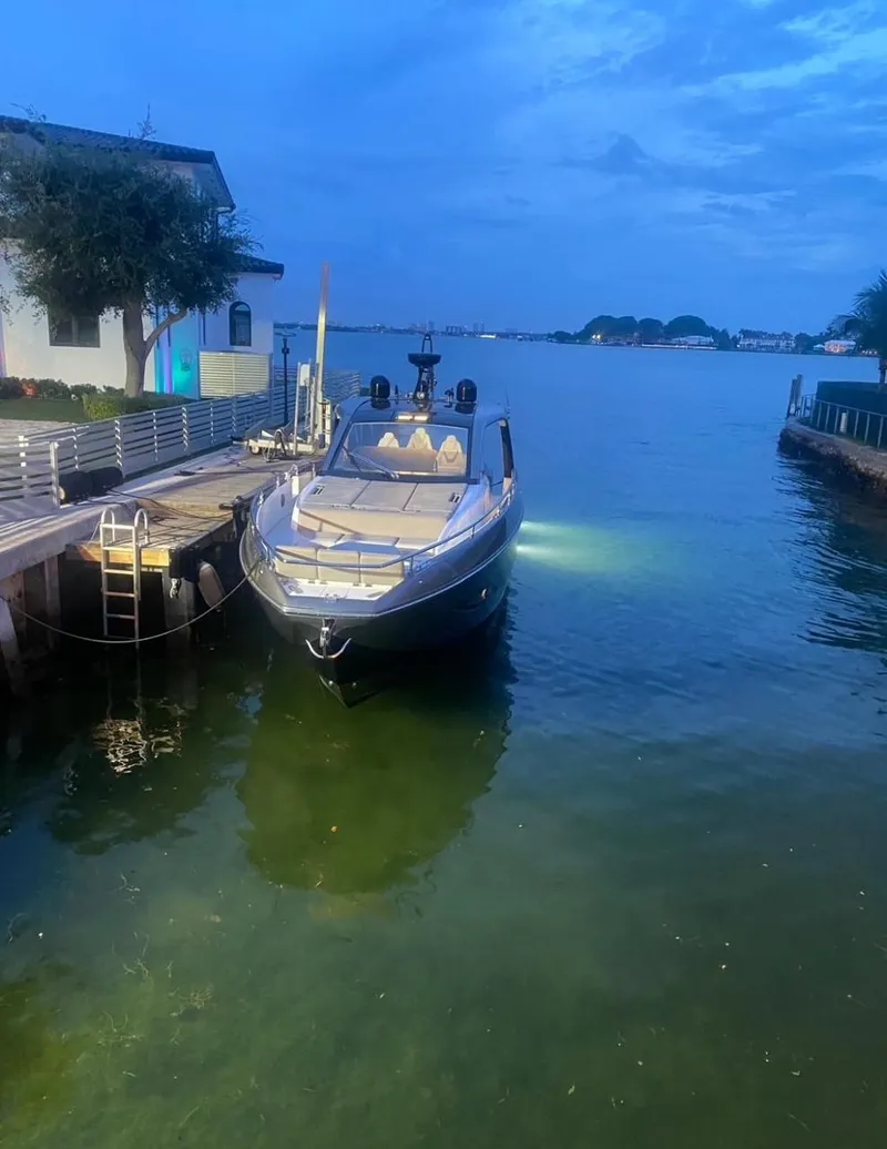 Slide: The Image of 2021 Azimut Verve 47 yacht docked at a serene waterfront during twilight. - 12