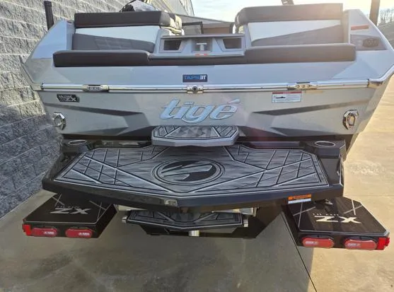 Slide: The Image of 2025 Tigé Ultré 23ZX boat rear view, featuring sleek design and branded swim platform. - 19
