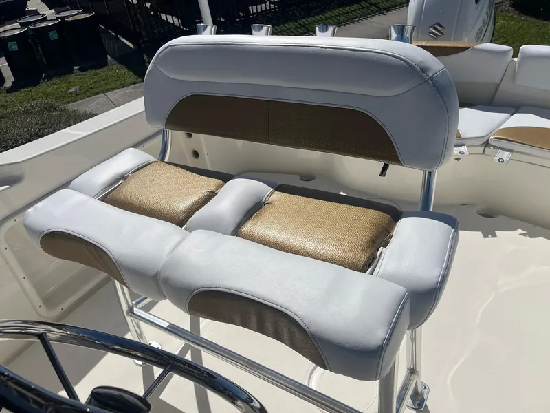 Slide: The Image of 2022 Bulls Bay 230 Center Console boat with cushioned seating and steering wheel. - 15