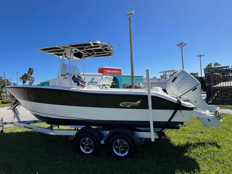 Slide: The Image of 2022 Bulls Bay 230 Center Console boat on trailer, parked on grass under clear blue sky. - 3