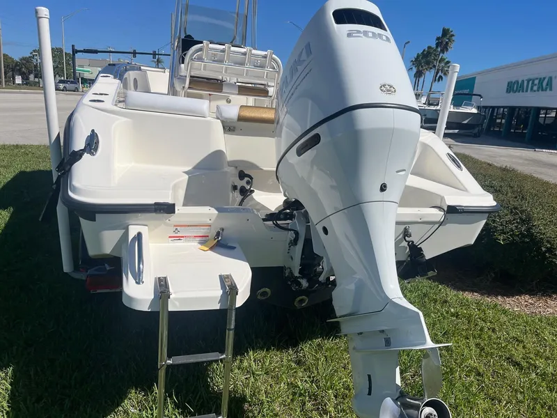 Slide: The Image of 2022 Bulls Bay 230 Center Console boat with outboard motor, parked on grass. - 4