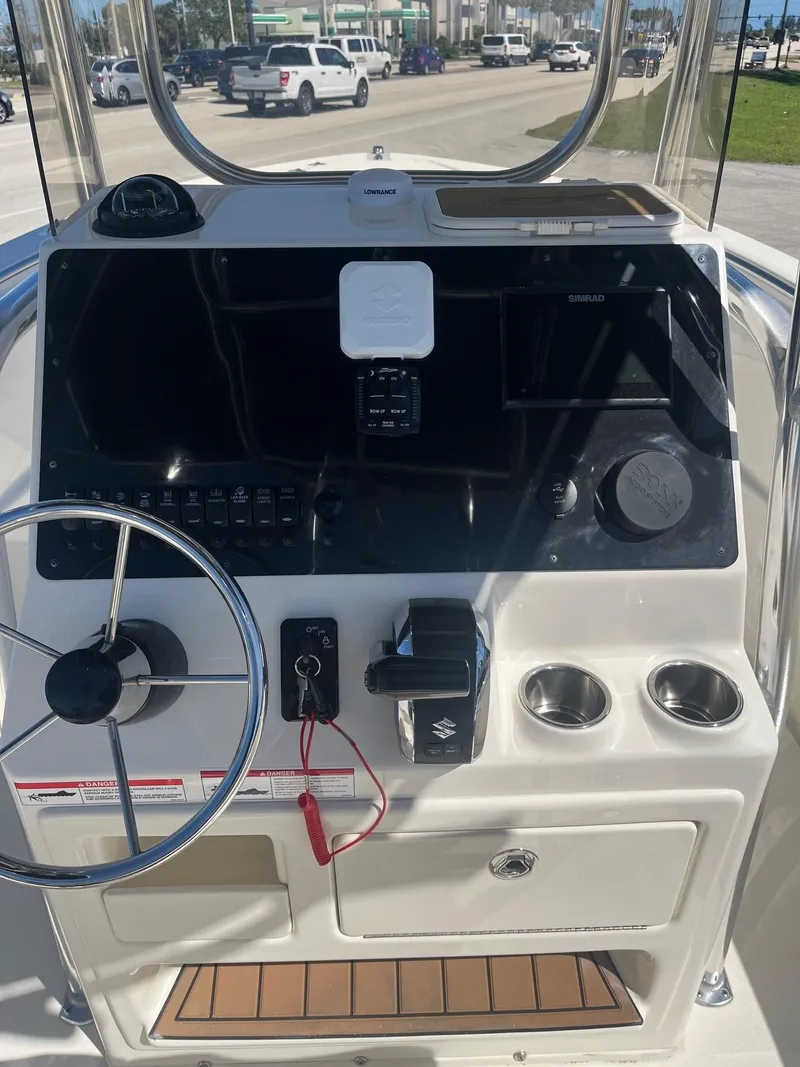 Slide: The Image of 2022 Bulls Bay 230 Center Console boat dashboard with steering wheel and controls. - 5