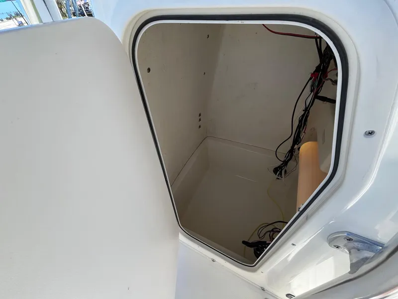 Slide: The Image of 2022 Bulls Bay 230 Center Console storage compartment with visible wiring. - 8