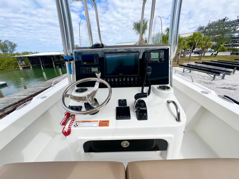 Slide: The Image of 2019 Parker 2300 Center Console boat dashboard with steering wheel and navigation equipment. - 15