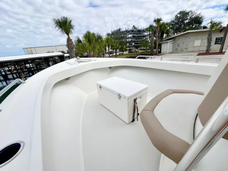 Slide: The Image of 2019 Parker 2300 Center Console boat interior with seating and cooler, dockside view. - 19