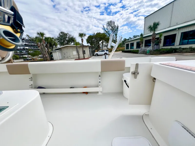 Slide: The Image of 2019 Parker 2300 Center Console boat interior with seating and storage, parked outdoors. - 6