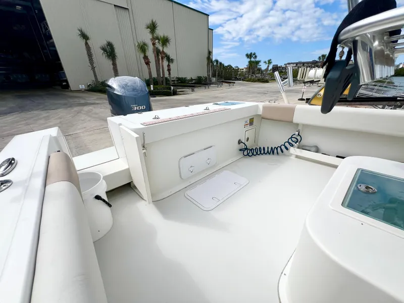 Slide: The Image of 2019 Parker 2300 Center Console boat interior with storage and seating, docked outdoors. - 7