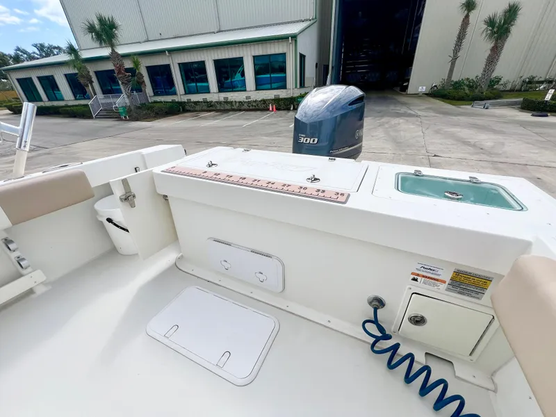 Slide: The Image of 2019 Parker 2300 Center Console boat with Yamaha 300 engine, docked near a warehouse. - 8