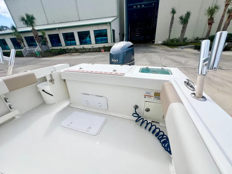 Slide: The Image of 2019 Parker 2300 Center Console boat interior with Yamaha engine, docked near a warehouse. - 9